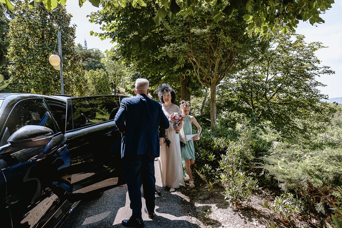 Fotografo matrimonio in Monferrato. Matrimonio di Serena e Fabrizio al Vecchio Castagno di Cocconato d'Asti. Sposa scende dall'auto.