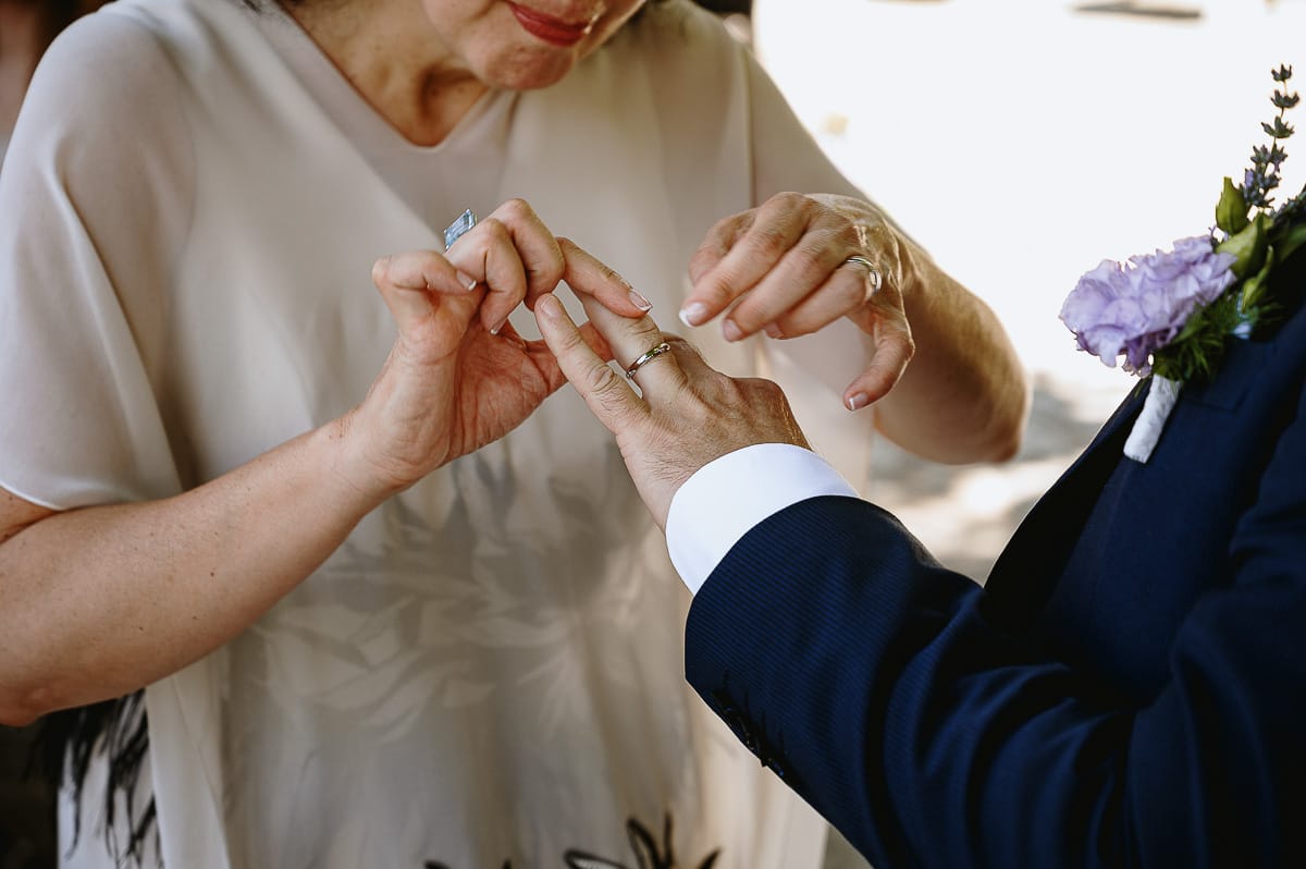 Fotografo matrimonio in Monferrato. Matrimonio di Serena e Fabrizio al Vecchio Castagno di Cocconato d'Asti. Cerimonia. Sposa infila l'anello allo sposo.