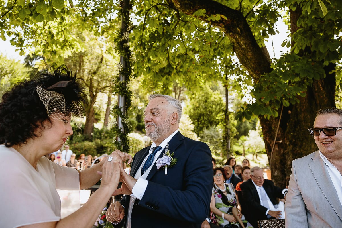 Fotografo matrimonio in Monferrato. Matrimonio di Serena e Fabrizio al Vecchio Castagno di Cocconato d'Asti. Cerimonia. Sposa infila l'anello allo sposo con fatica