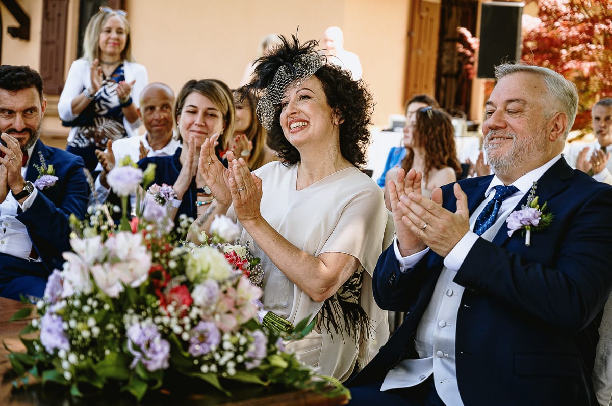 Fotografo matrimonio in Monferrato. Matrimonio di Serena e Fabrizio al Vecchio Castagno di Cocconato d'Asti. Cerimonia. Sposi applaudono.