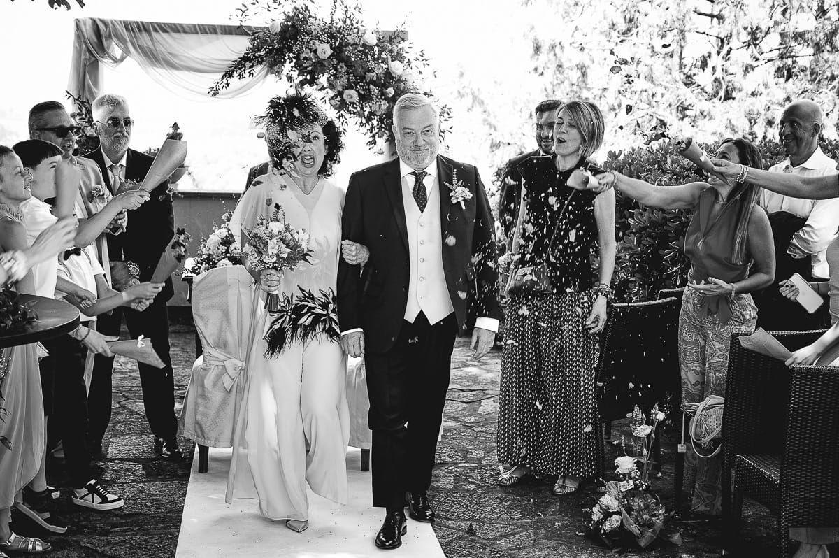 Fotografo matrimonio in Monferrato. Matrimonio di Serena e Fabrizio al Vecchio Castagno di Cocconato d'Asti. Cerimonia. Uscita degli sposi con lancio dei petali. Bianco e nero