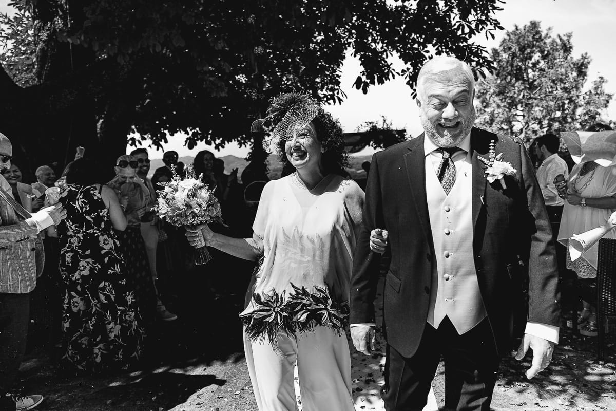 Fotografo matrimonio in Monferrato. Matrimonio di Serena e Fabrizio al Vecchio Castagno di Cocconato d'Asti. Cerimonia. Uscita degli sposi con lancio dei petali. Bianco enero.
