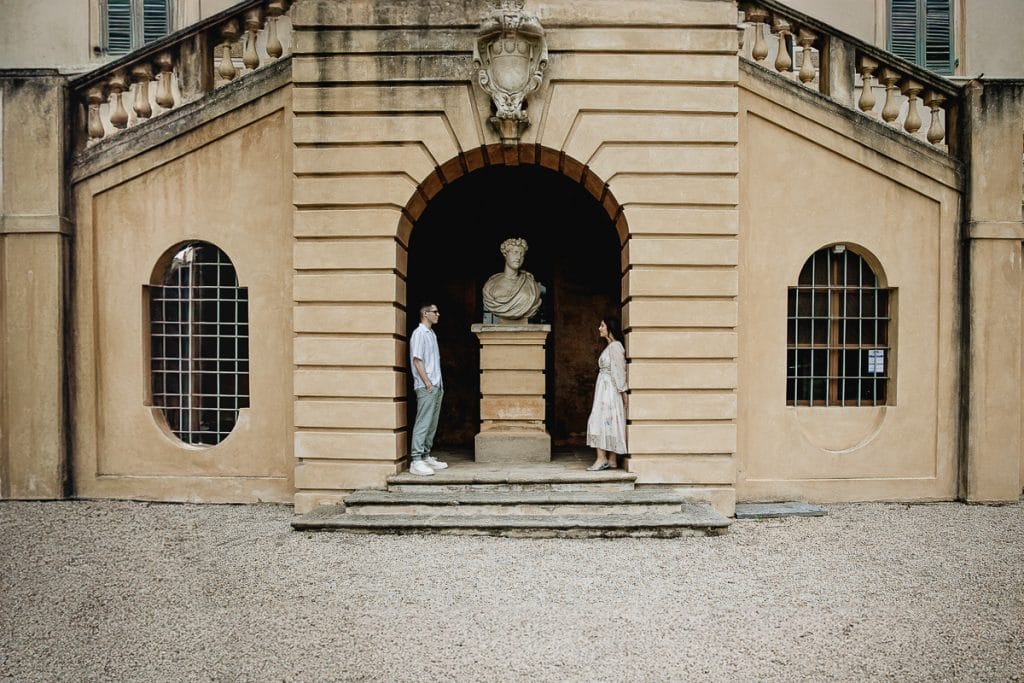 During the pre-wedding shoot at Castello di Santena, Fabiola and Cristian retreat to a secluded corner, under the staircase, where an intense gaze unites them, while a statue seems to watch over their promise of love. 
