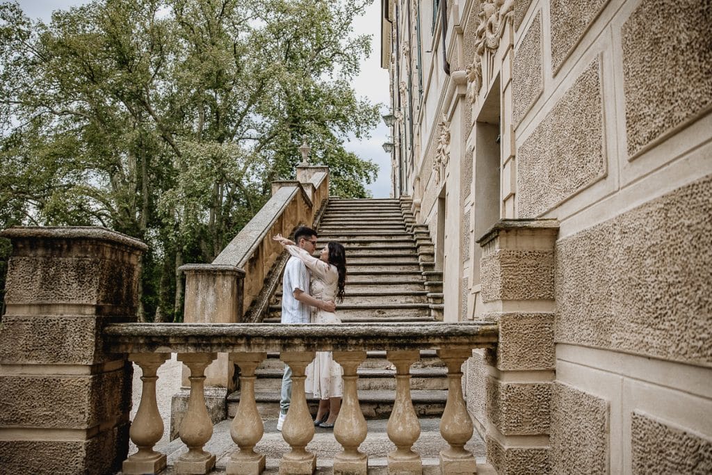 A magical pre-wedding at Castello di Santena. Fabiola and Cristian share a tender moment on the castle steps, her arms lovingly wrapped around his neck.  