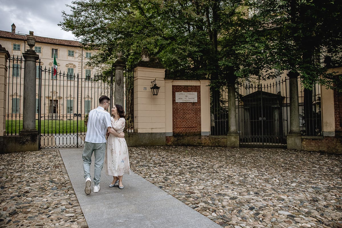 Pre-wedding al Castello di Santena. Fabiola e Cristian davanti al cancello del castello camminano abbracciati guardandosi.