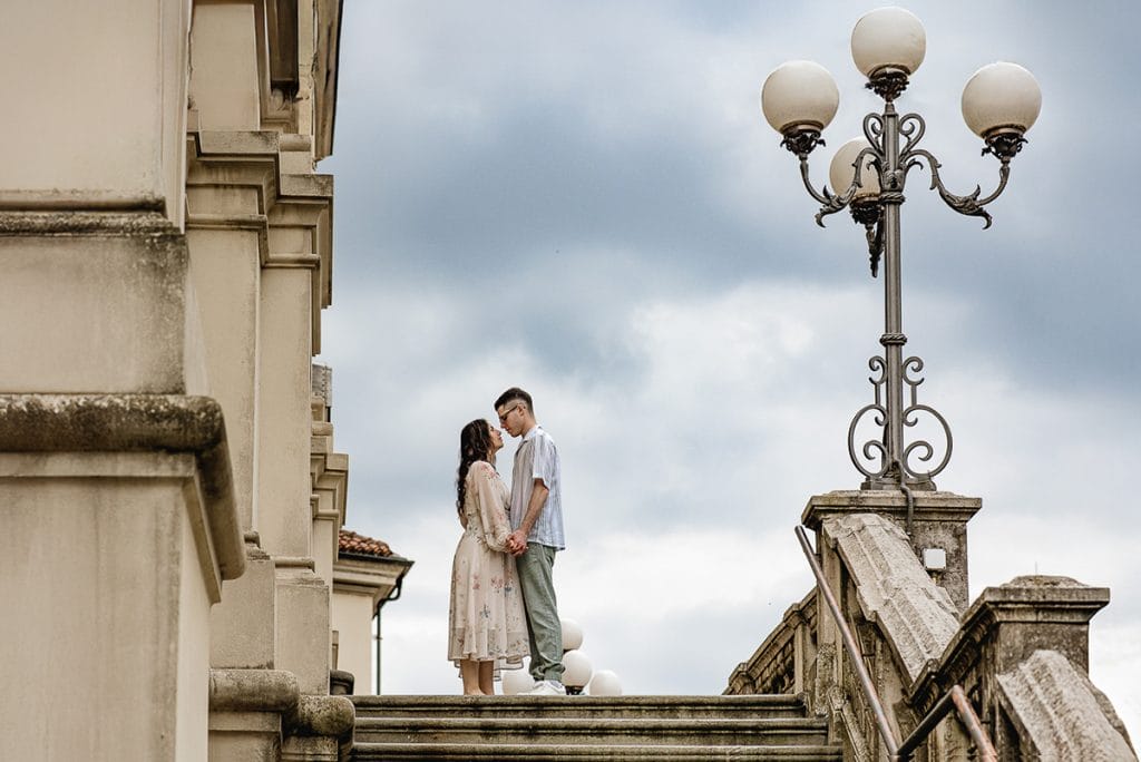 Pre-wedding at Castello di Santena. Fabiola and Cristian look at each other on the church steps. 