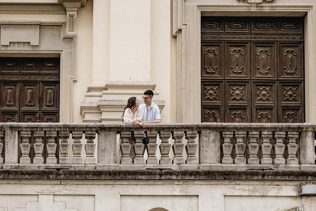 Pre-wedding at Castello di Santena. Fabiola and Cristian look at each other on the stone balcony of the church. 