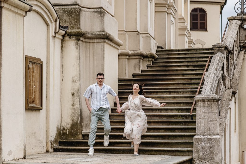 A playful moment captured on the church steps: Fabiola and Cristian joyfully skip down the last step during their pre-wedding at Castello di Santena. 