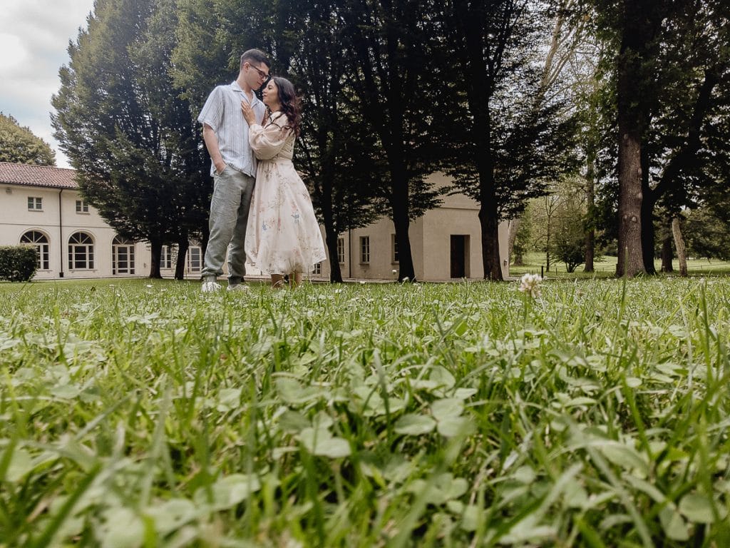 Pre-wedding at Castello di Santena. Fabiola and Cristian gaze into each other's eyes. Aerial drone shot from the grass.  