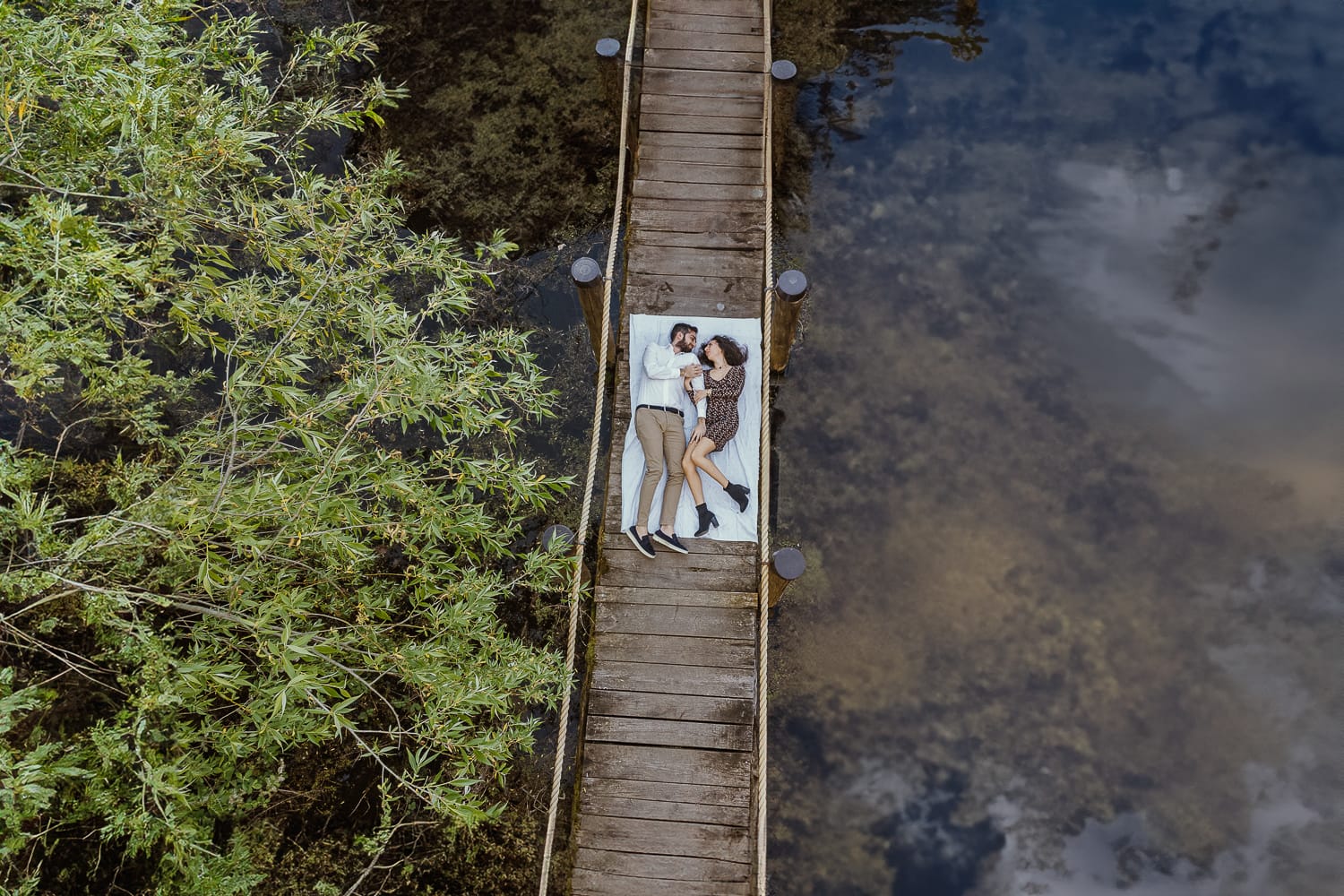 Pre-wedding al Lago di Viverone di Ilaria e Luca. Foto aerea dal drone della coppia sdraiata sul pontile del Lago