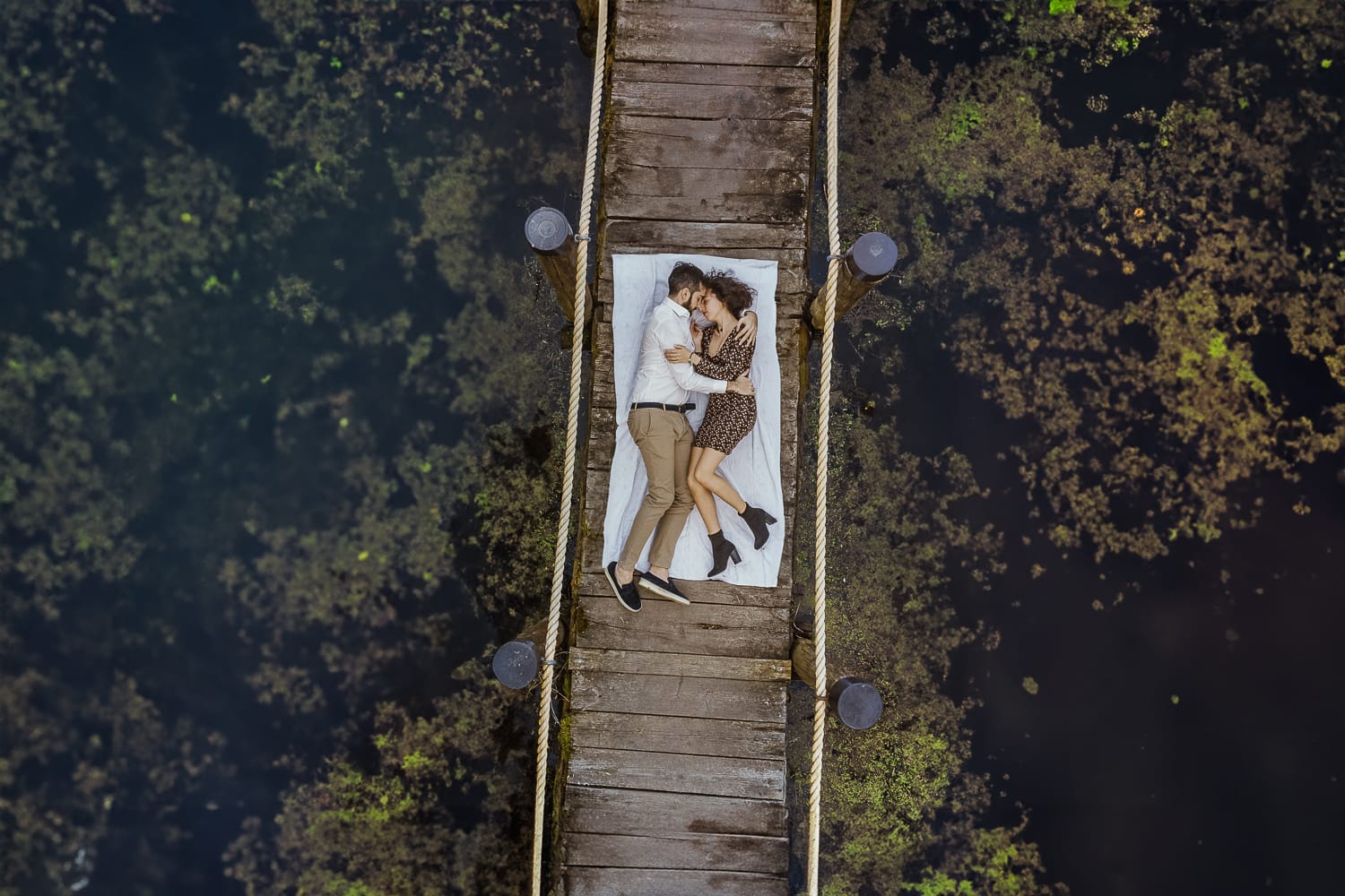 Pre-wedding al Lago di Viverone di Ilaria e Luca. Foto aerea dal drone della coppia sdraiata sul pontile del Lago