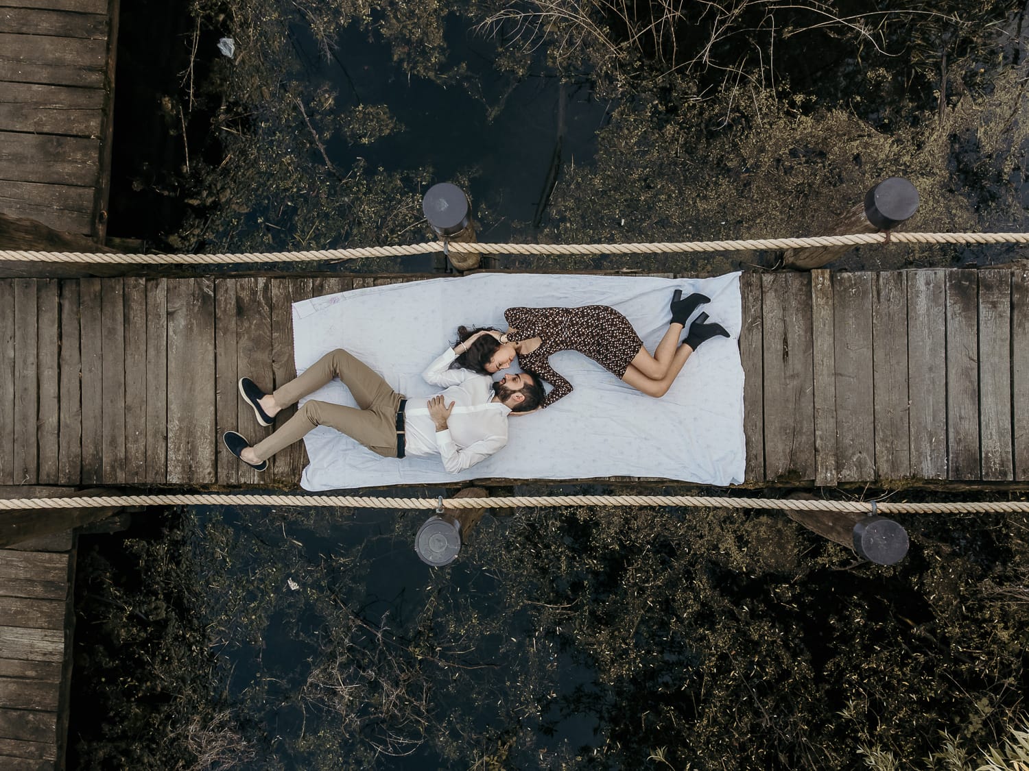 Pre-wedding al Lago di Viverone di Ilaria e Luca. Foto aerea dal drone della coppia sdraiata sul pontile del Lago