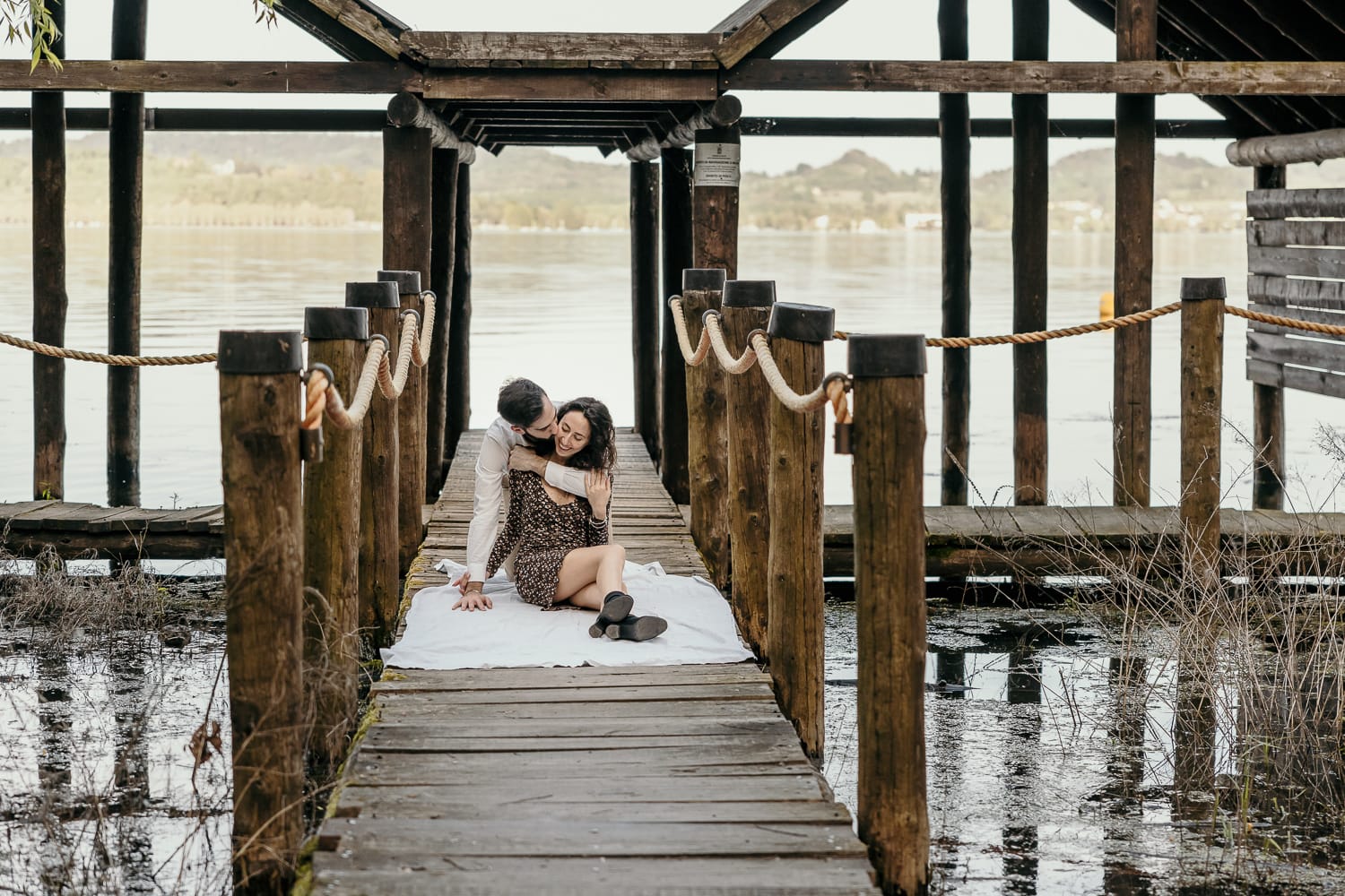 Pre-wedding al Lago di Viverone di Ilaria e Luca. Foto della coppia seduta sul pontile del Lago