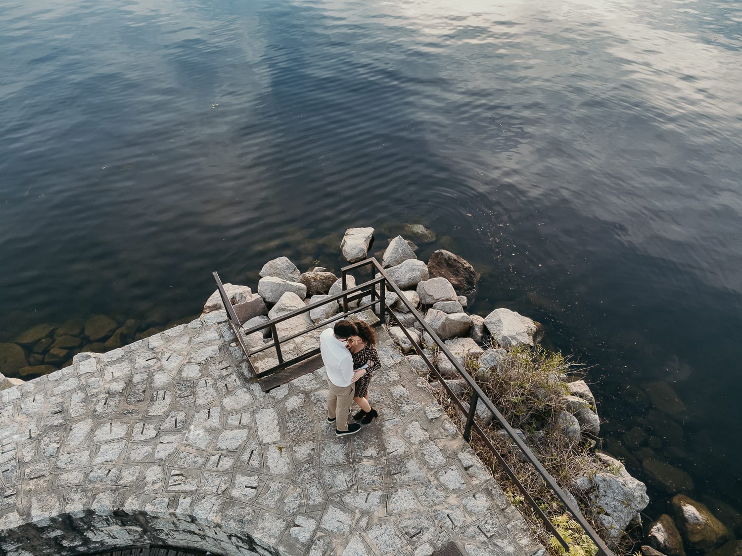Pre-wedding al Lago di Viverone di Ilaria e Luca. Foto aerea dal drone della coppia sul pontile di pietra.