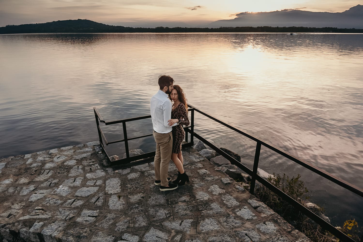 Pre-wedding al Lago di Viverone di Ilaria e Luca. Foto aerea dal drone della coppia fronte fronte con sullo sfondo il tramonto sul lago.