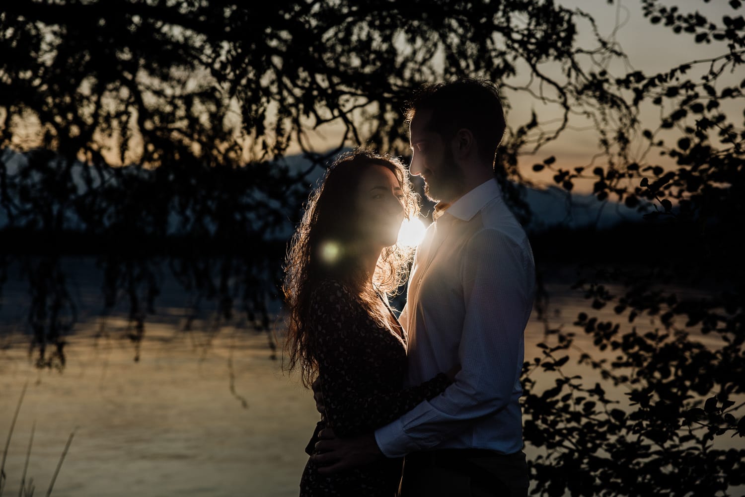Pre-wedding al Lago di Viverone di Ilaria e Luca. Coppia davanti al lago con il flash esterno dietro di loro.