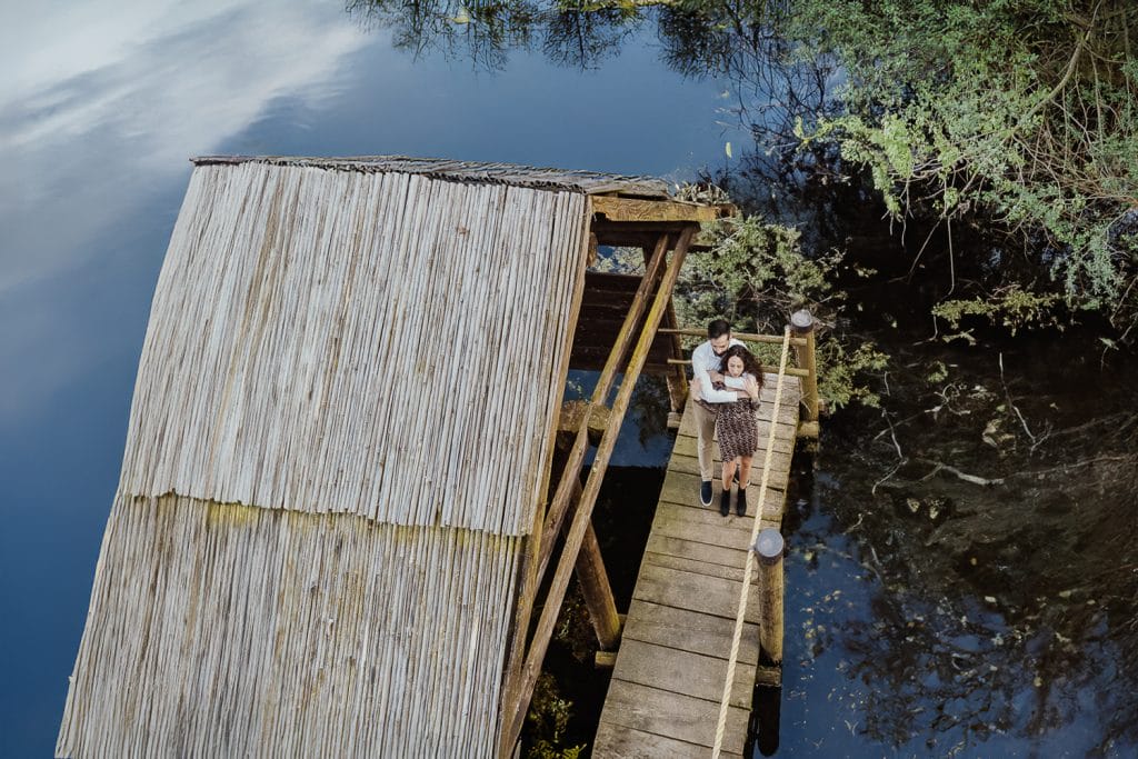 Ilaria and Luca's enchanting pre-wedding shoot at Lake Viverone. Aerial drone capture of the couple against the backdrop of prehistoric pile dwellings. 