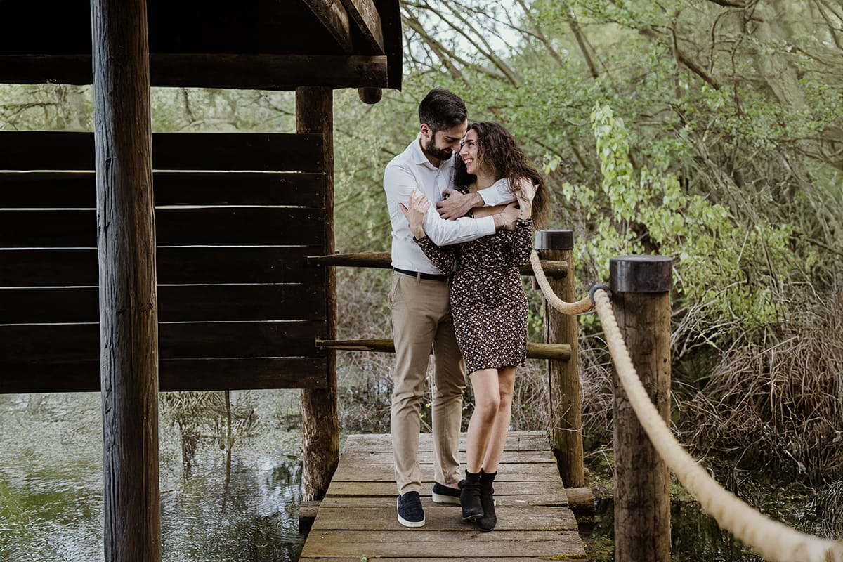 Pre-wedding al Lago di Viverone di Ilaria e Luca. Luca abbraccia Ilaria da dietro sul pontile.