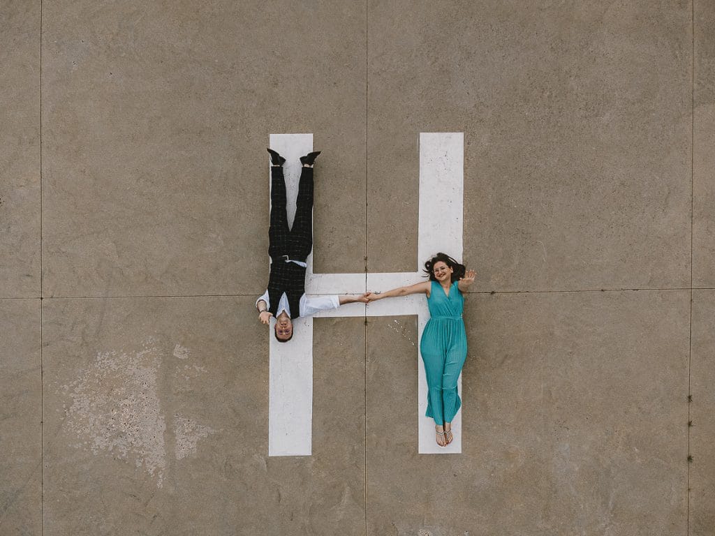 卡斯特尔努沃·顿·博斯科航空俱乐部的婚前拍摄。维多利亚和克里斯蒂安躺在直升机着陆跑道上的空中照片，背景是绿草如茵的草地。  