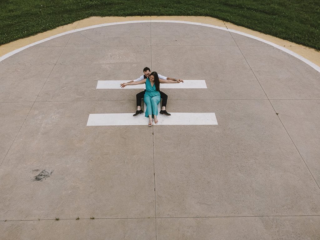 卡斯特尔努沃·顿·博斯科航空俱乐部的婚前拍摄。情侣坐在直升机着陆跑道上。来自无人机的空中照片。  