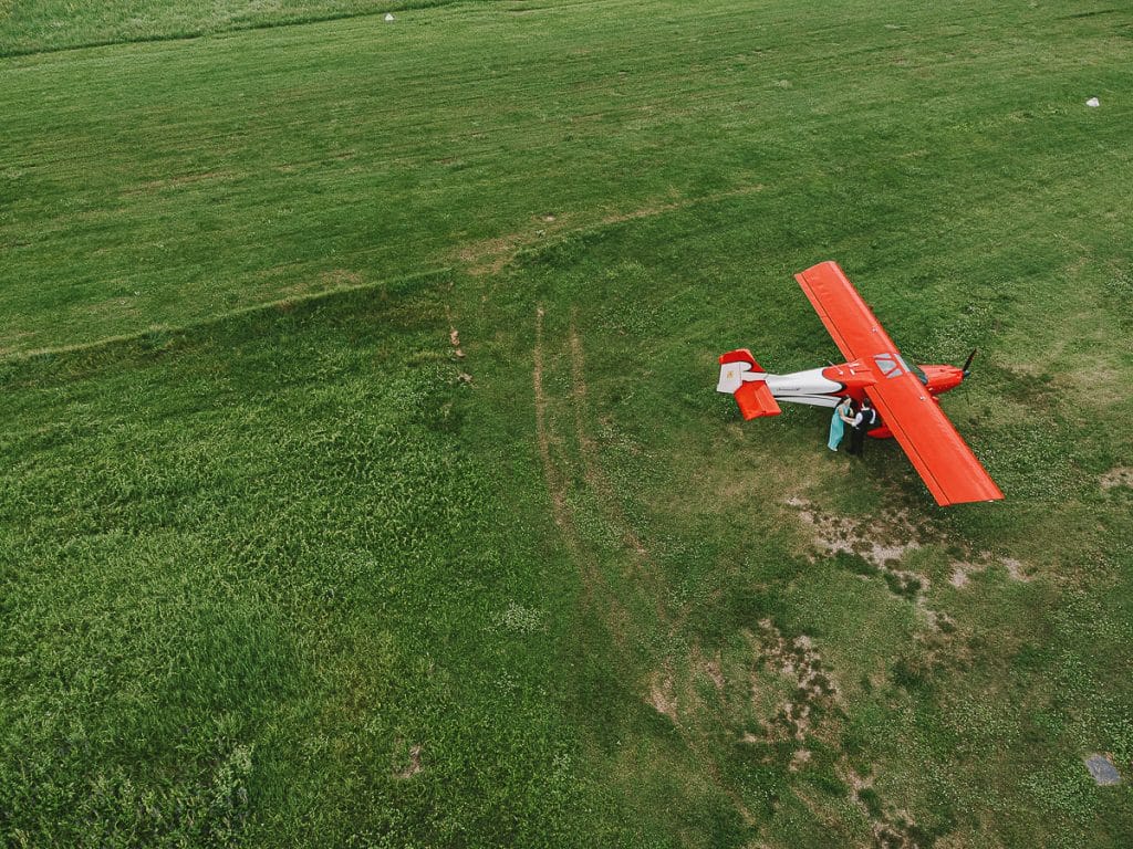 卡斯特尔努沃·顿·博斯科航空俱乐部的婚前拍摄。情侣站在飞机旁边。无人机拍摄的空中照片。  
