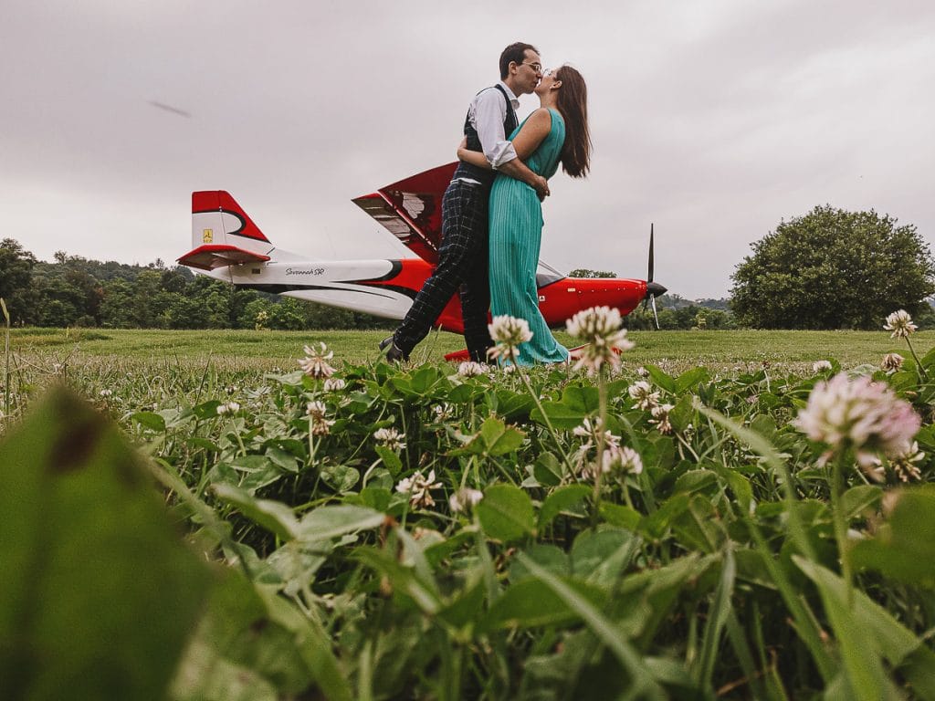 卡斯特尔努沃·唐·博斯科飞行俱乐部的婚前拍摄。情侣在飞机前亲吻。来自地面上的无人机拍摄。  