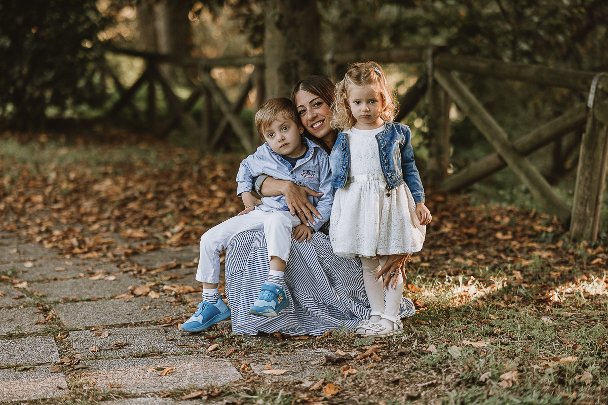 Fotografia di famiglia a Chieri, nel Giardino del Tessile. Ilenia accovacciata con i due bambini.