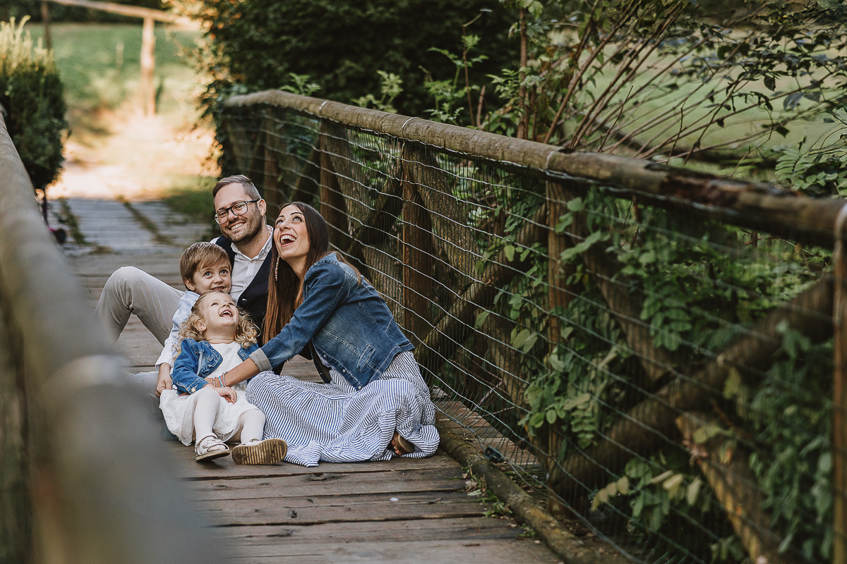 Fotografia di famiglia a Chieri, nel Giardino del Tessile. La famiglia è seduta sul ponte di legno sopra il Rio Tepice.