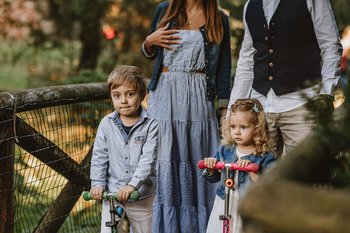 Fotografia di famiglia a Chieri, nel Giardino del Tessile. La famiglia è sul ponte di legno sopra il Rio Tepice. I bambini sono sui monopattini.