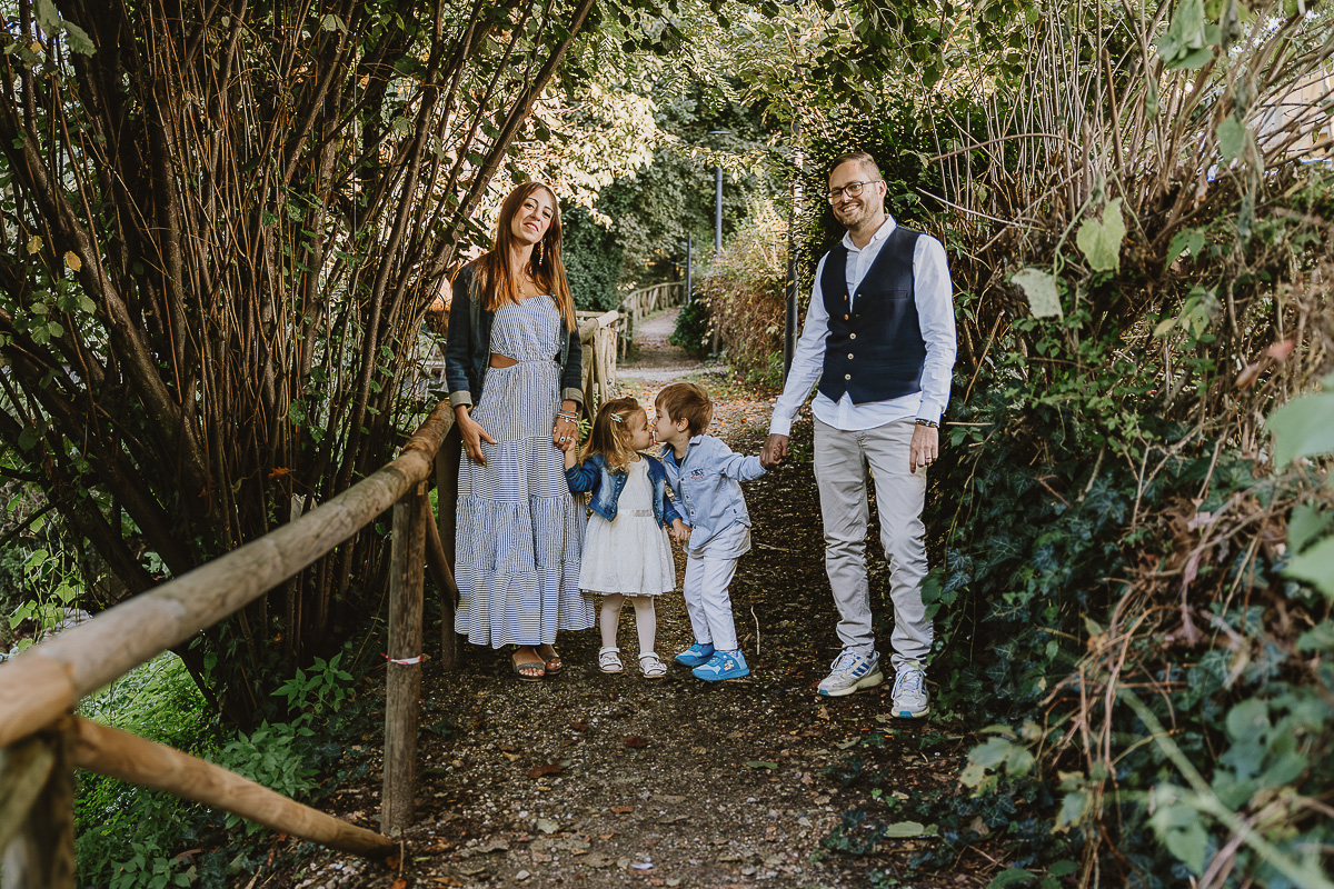 Fotografia di famiglia a Chieri, nel Giardino del Tessile. La famiglia cammina sul vialetto.