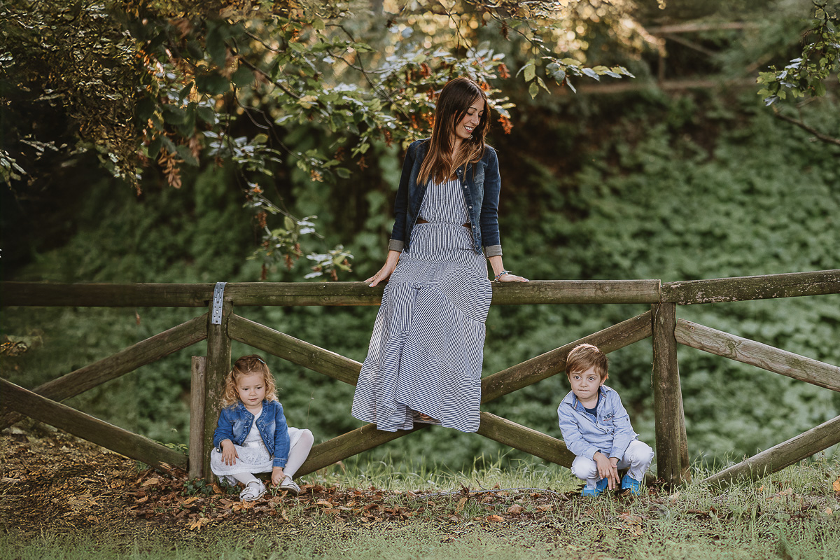 Fotografia di famiglia a Chieri, nel Giardino del Tessile. Ilenia seduta sulla staccionata di legno e i bambini in basso.