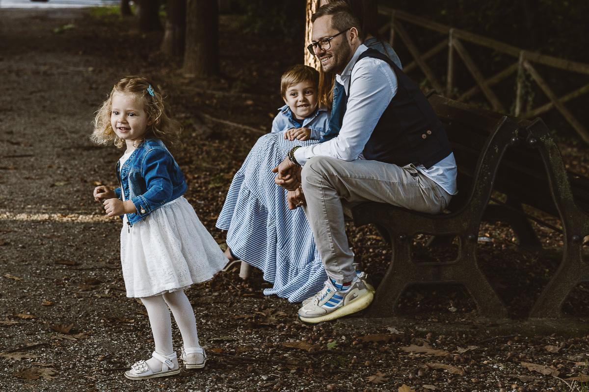 Fotografia di famiglia a Chieri, nel Giardino del Tessile. Mentre i genitori e il fratello sono seduti su di una panchina, Cammi, balla.