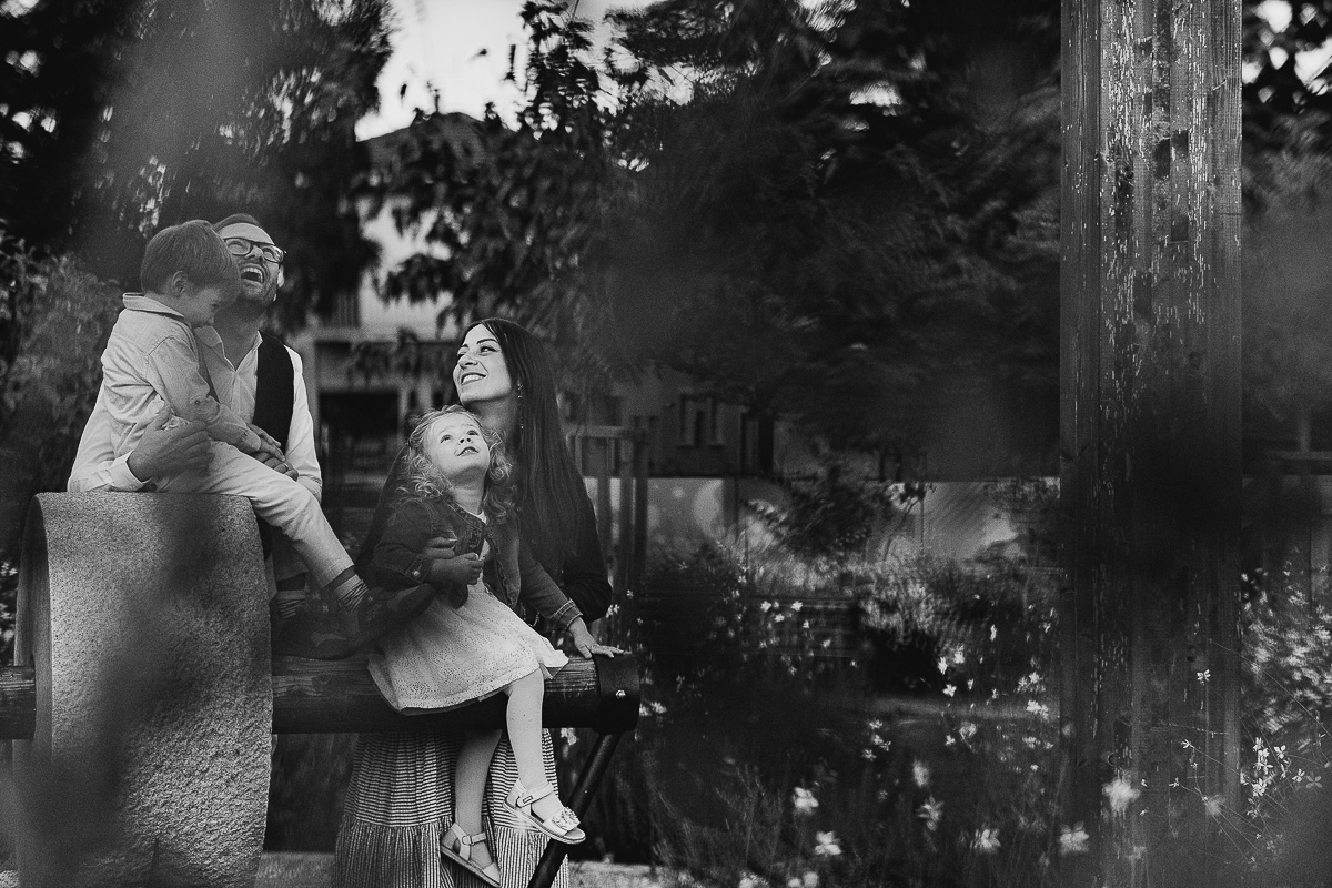 Fotografia di famiglia a Chieri, nel Giardino del Tessile. Tutta la famiglia vicino alla Macina. I bambini sono seduti sulla Macina. Foto in bianco e nero.