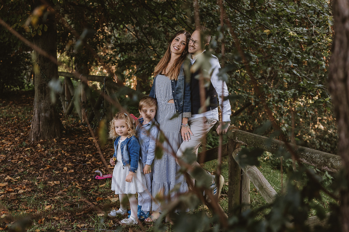 Fotografia di famiglia a Chieri, nel Giardino del Tessile. Ritratto di famiglia attraverso i rami degli alberi.