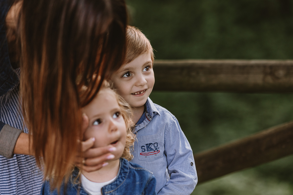 Fotografia di famiglia a Chieri, nel Giardino del Tessile. Ilenia tiene il viso di cami tra le mani, dietro si vede il fratellino.