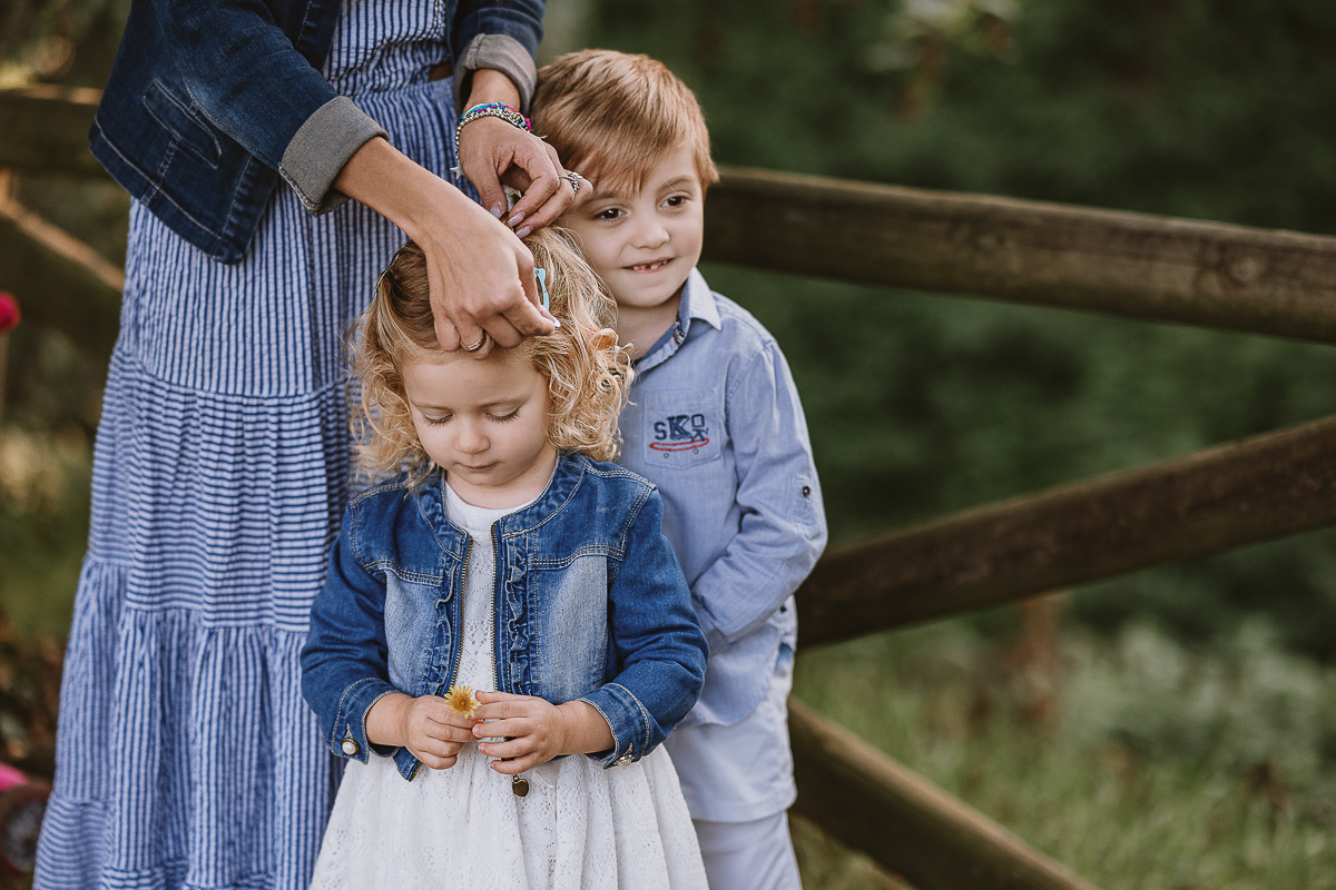 Fotografia di famiglia a Chieri, nel Giardino del Tessile. Ileni sistema i capelli di Camilla.