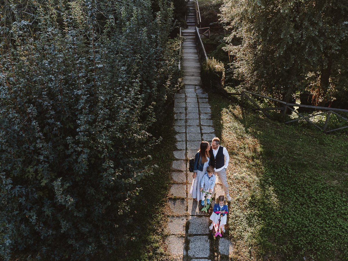 Fotografia di famiglia a Chieri, nel Giardino del Tessile. Igenitori si baciano.