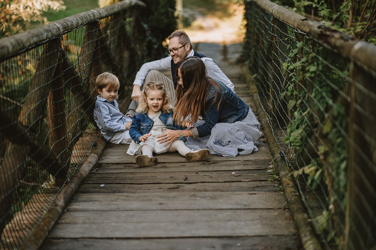Fotografia di famiglia a Chieri, nel Giardino del Tessile. La famiglia è seduta sul ponte di legno sopra il Rio Tepice.