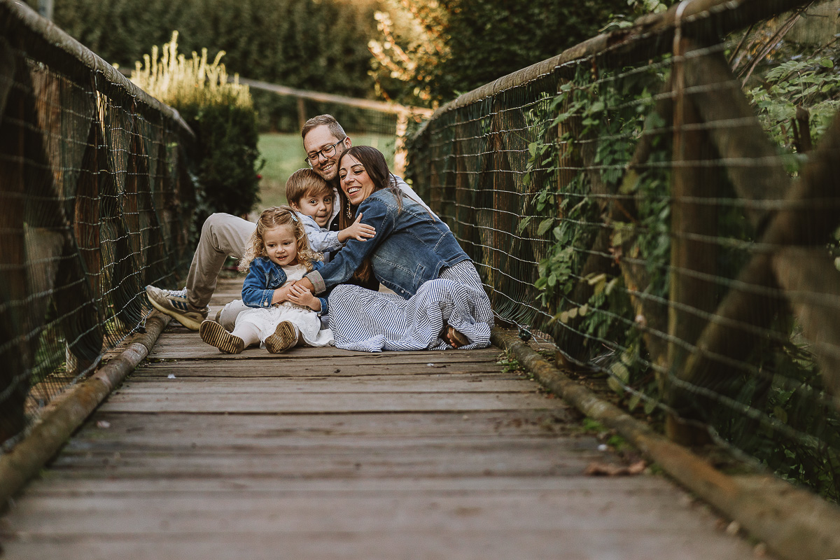 Fotografia di famiglia a Chieri, nel Giardino del Tessile. La famiglia è seduta sul ponte di legno sopra il Rio Tepice.