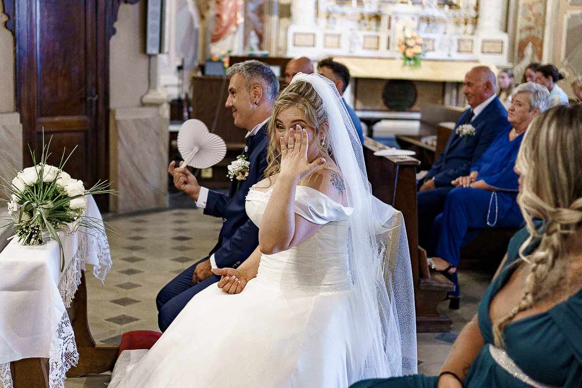 Fotografo Matrimonio in Piemonte. Cerimonia nella chiesa di San Giovanni Battista di Moriondo Torinese. Sposa mostra la fede nuziale.