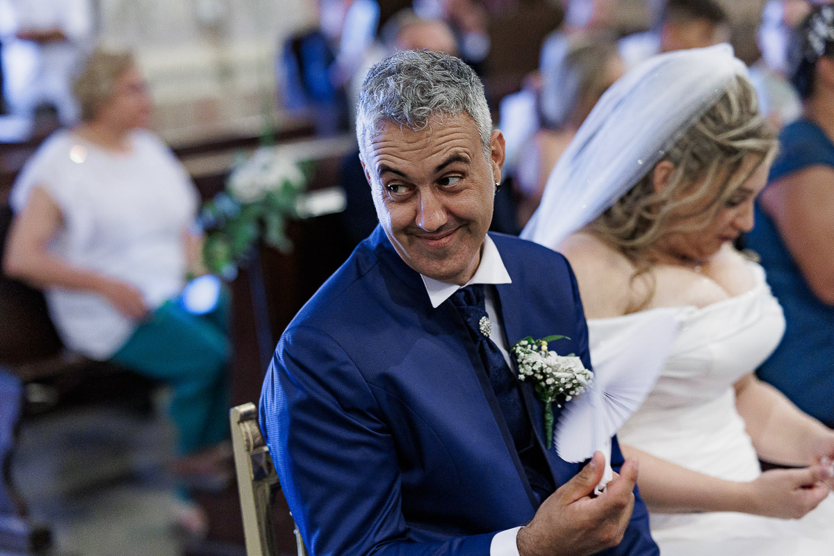 Fotografo Matrimonio in Piemonte. Cerimonia nella chiesa di San Giovanni Battista di Moriondo Torinese. sposo con un'espressione buffa.