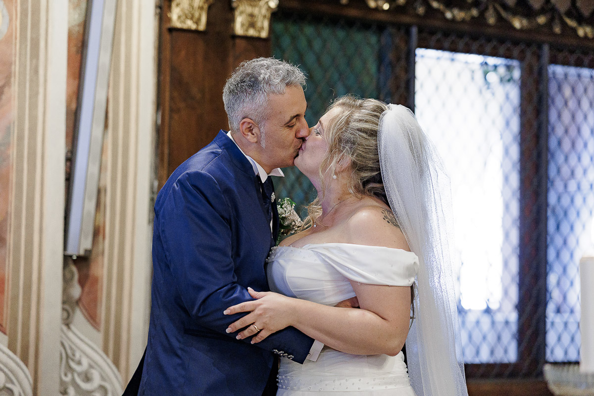 Fotografo Matrimonio in Piemonte. Cerimonia nella chiesa di San Giovanni Battista di Moriondo Torinese. bacio degli sposi.