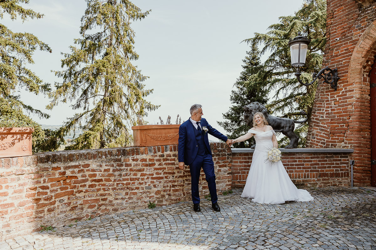 Fotografo Matrimonio in Piemonte. Ritratti di coppia degli sposi davanti al castello di Moriondo Torinese. Sposo tira la sposa.