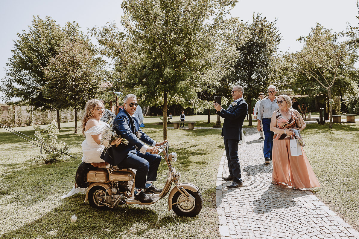 Fotografo Matrimonio in Piemonte. Ricevimento all'agriturismo Greppi di crescentino (VC). Gli sposi sulla Lambretta d'epoca arrivano nella zona aperitivo.