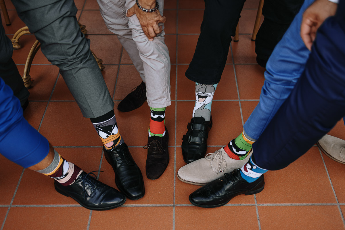 Fotografo Matrimonio in Piemonte. Ricevimento all'agriturismo Greppi di Crescentino (VC). Pranzo nuziale. Sposo e amici tutti con calzini buffi a tema cartoni animati.