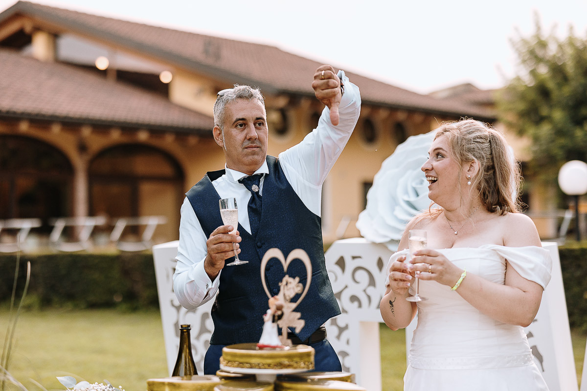 Fotografo Matrimonio in Piemonte. Ricevimento all'agriturismo Greppi di Crescentino (VC). Ricevimento. Taglio torta. Lo sposo apre la bottiglia di spumante