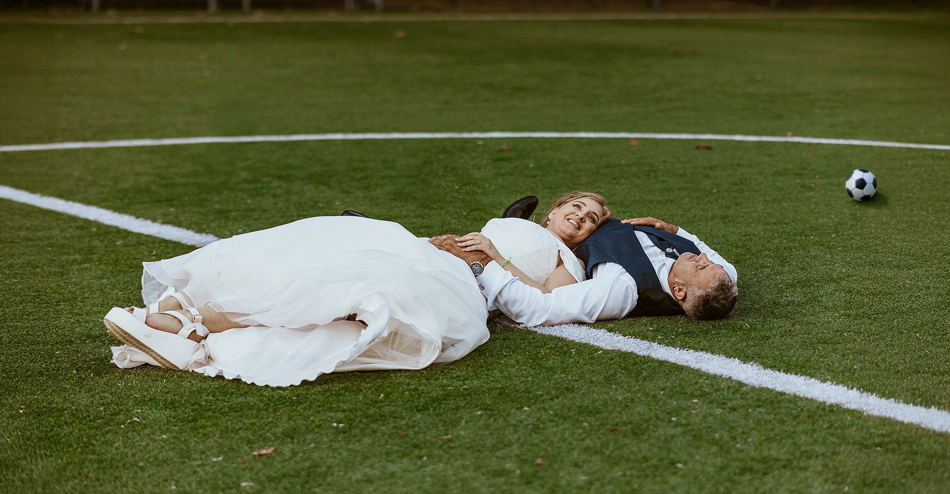 Fotografo Matrimonio in Piemonte. Ricevimento all'agriturismo Greppi di Crescentino (VC). Ricevimento. Ritratto degli speso sul campo di calcio. Sposi sdraiati sull'erba del terreno di gioco.