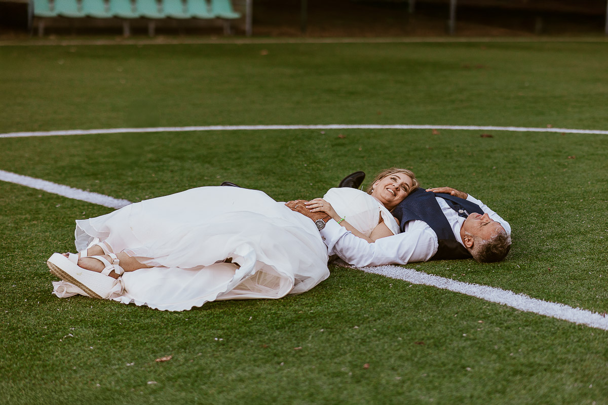 Fotografo Matrimonio in Piemonte. Ricevimento all'agriturismo Greppi di Crescentino (VC). Ricevimento. Ritratti degli sposi al campo di calcio. Sposi sdraiati sul terreno da gioco.