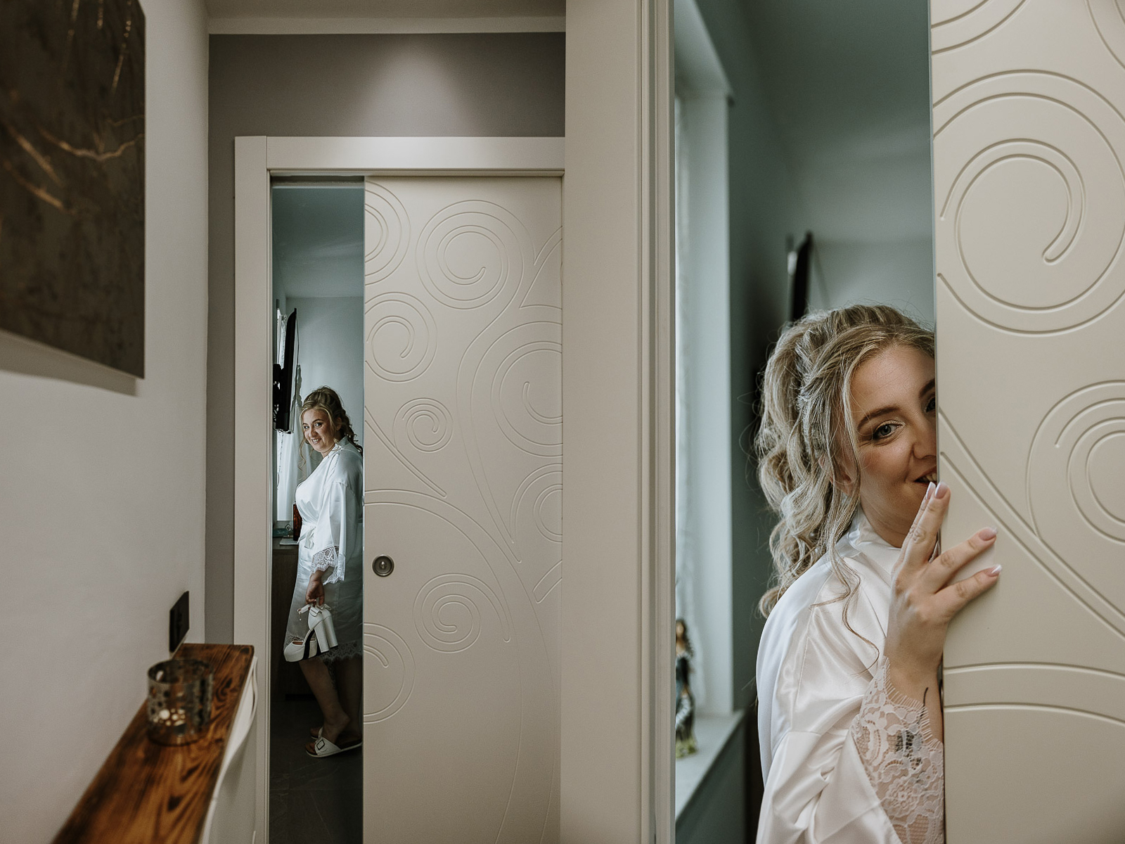 Fotografo Matrimonio in Piemonte. Preparazione a Moncucco Torinese. Sposa vista attraverso una porta.