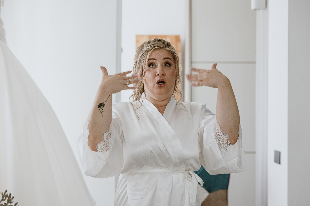 Fotografo Matrimonio in Piemonte. Preparazione a Moncucco Torinese. Sposa commossa agita le mani.